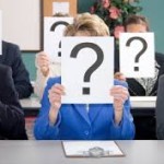 Anonymous business people holding up question marks